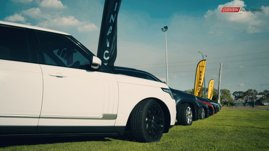 Image of cars lined up on a grass verge.